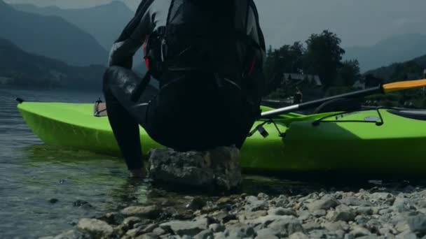 Kayaker vilar på strandlinjen rock. Kajakpaddling sport. — Stockvideo