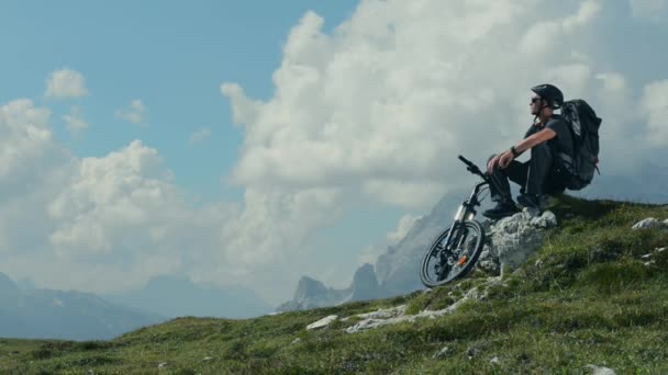 Motociclista descansando en el sendero de la montaña y disfrutando de un gran panorama de la montaña . — Vídeo de stock