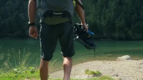 Wandelaar wandelen op het bergmeer rotsachtige kust genieten van het moment. — Stockvideo