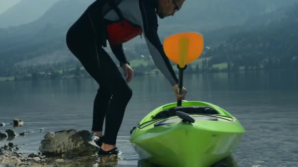 Kayaker despegando. Kayak en el lago escénico de la montaña . — Vídeo de stock