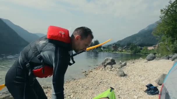 Män förbereder sig för kajaktur på sjön — Stockvideo