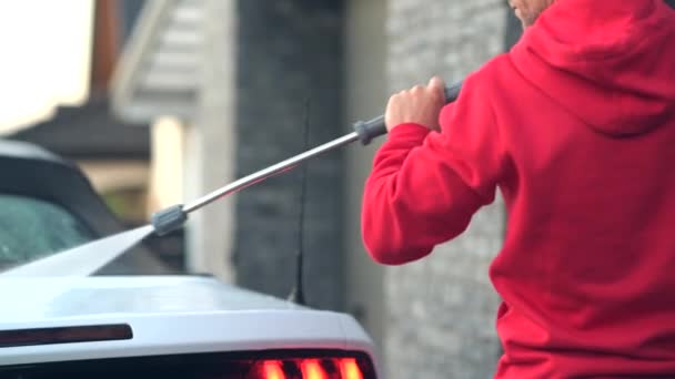 Kaukasische mannen in zijn 30s met behulp van hogedrukreiniger te wassen zijn moderne cabriolet auto. — Stockvideo