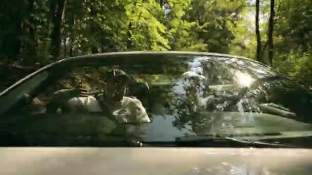 Due amici caucasici maschi sulla strada per la destinazione delle vacanze. Due ragazzi nella moderna auto convertibile . — Video Stock