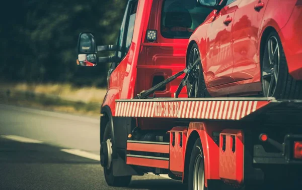 Vehículo tractor con un coche — Foto de Stock