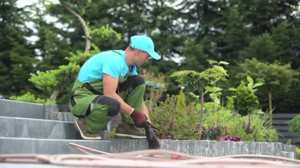 Bouwen van nieuwe woon tuin door Kaukasische tuinier in zijn 30s. — Stockvideo