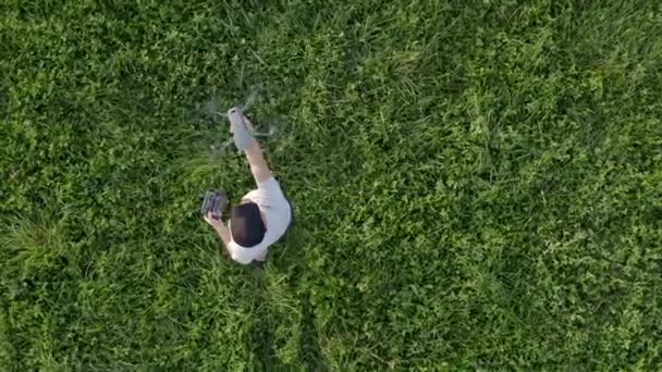 Kaukaski mężczyźni w jego 30s z Drone przebywających w środku łąki. — Wideo stockowe