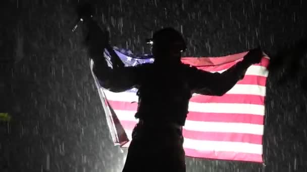 Soldado orgulloso del ejército americano con bandera nacional en las manos durante una fuerte tormenta — Vídeos de Stock