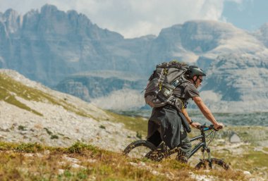 İtalya 'nın Misurina kenti yakınlarındaki İtalyan Dolomitlerin Dağ Yolu' nda Büyük Sırt Çantası Giyen Beyaz Bisikletli. Açık hava Spor ve Eğlence Teması. Bir Bisikletin Yaz Sezonu.