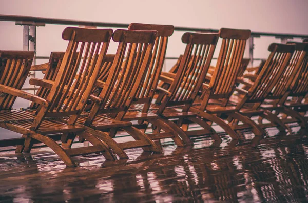 旅游业问题 空的和湿的木制游轮甲板座椅 — 图库照片
