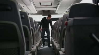 Şehir içi otobüs şoförü otobüsünü hazırlıyor. Müşterilerin ve çöplerin bıraktıklarını arıyor..