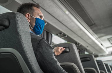 Yüzünde Solunum Maskesi Yüzünde Bir Otobüs Arabasında Tek Başına Seyahat Eden Adamlar. Pandemia sırasında toplu taşıma. Kamu Yerlerinde Güvenlik Tedbirleri.