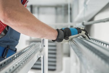 Depo Havalandırma Sistemi Metal Çerçevesi. Endüstri Teması. Kafkas İşçi Metalik Rayları Hazırlıyor.