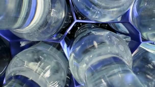 Szklane Butelki Napełnione Wodą Mineralną Niebieskich Plastikowych Rozdzielaczach — Wideo stockowe