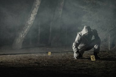 Olay Yeri İnceleme Uzmanı 'nın Hazmat Giysisi ve Eldiveni' ne yerleştirdiği İz ve Kanıt İşaretleri Aranıyor. Karanlık Sisli Orman. Suç Sahnesi Teması Konsepti.
