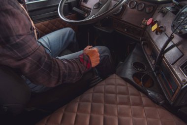 Kafkasyalı yarı kamyon şoförü direksiyonun arkasında. Yıllanmış Vintage Truck 'ta manuel şanzıman. Ulaşım Endüstrisi.