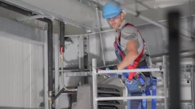 Erkek Teknisyen, hava sirkülasyon sisteminin yalıtımlı boru bağlantılarını sıkılaştırıyor ve ayarlıyor.. 