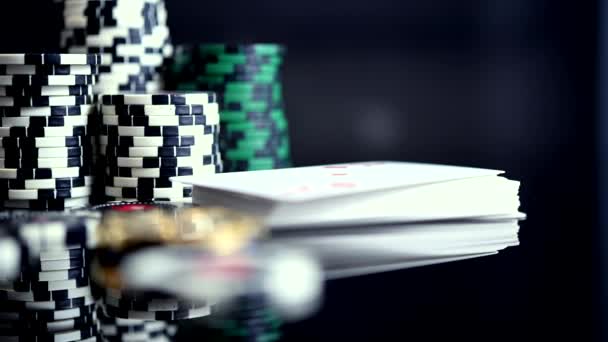 テーブルの上にポーカーチップのトランプとマルチカラーの杭のスタックとカジノのコンセプト — ストック動画