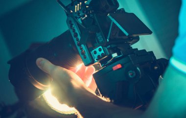 Profesyonel Dijital SLR Kamera Operatörü. Elinde ekipman var. Videografi ve Sinema Üretim Ekipmanı. 