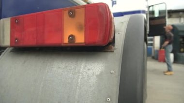 Yarı park edilmiş kamyonun arkasındaki büyük kırmızı ve turuncu sinyal ışığını kapat.. 