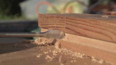 Elektrikli matkap sürücüsü kullanarak Ahşap Tahtada Delik Açan İşçinin Kapanışı. 