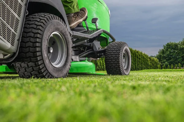 庭と造園のテーマ 屋外電源装置芝刈り機のトラクターの仕事に乗る 草刈り作業 — ストック写真