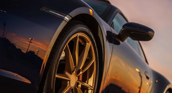 スーパーカーボディの風景日没反射 大型ゴールデン合金ホイールとスポーティルッキング車両 自動車のコンセプト — ストック写真
