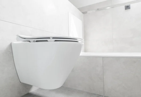壁に取り付けられた大きなセラミックタイルと白いトイレ付きのバスルームのモダンなシンプルなデザイン — ストック写真