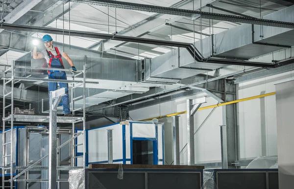 Ticari Bina 'da, Flashlight Nezaret Bakışlı Profesyonel Havalandırma Teknisyeni. Kırklı yaşlarda beyaz bir işçi. Endüstriyel Tema.