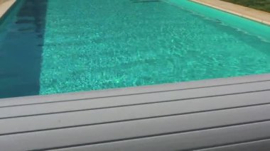 Sıcak yaz gününde üst düzey özel mülkte kristal berrak suyla dolu sığ havuz.  