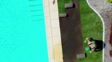 Bahçe düzenleme müteahhitlerinin onları düzgün sıralara yerleştirmek için çim yerleştirme zemini hazırlarken çekilmiş hava görüntüsü. 