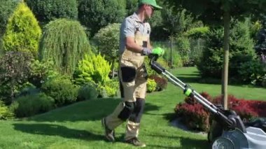 Beyaz adam bahçıvan, Estate Garden 'ın büyük otlak bölgesini kesiyor. Renkli bitkiler ve su kuyusuyla güzel tasarlanmış bereketli bir manzara.. 