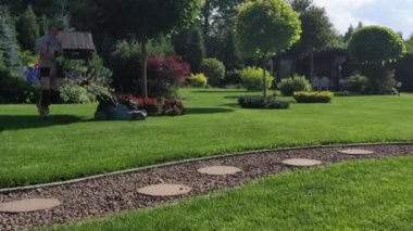 Olgunlaşan ve yerleşmiş geniş yeşil çimlerin ortasında yuvarlak patikaları olan kıvrımlı Rocky Pathway.. 