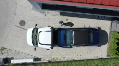 Çekici sürücünün hava görüntüsü etrafta dolanıyor ve süratli aracın düz karavanla nakledilişini iki kez kontrol ediyor.. 