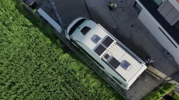 用高压洗衣机清洗野营车外面的人 停在大楼后面的汽车住房的空中景观 — 图库视频影像