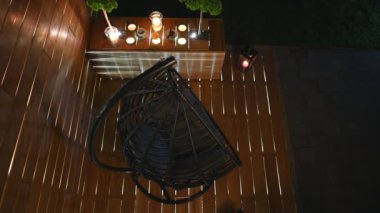 Geceleri konforlu asılı Oval Sandalye ile Woden Veranda Işığı 'nın üstünde..  