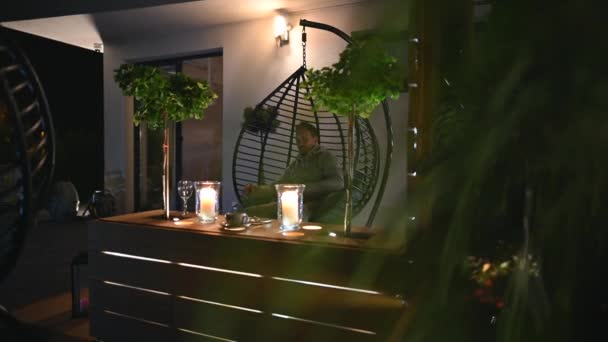 Moderne Terrassendekoration Der Nacht Mit Hängesessel Holztheke Tisch Dekorative Pflanzen — Stockvideo