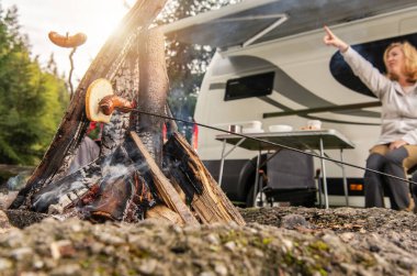 Summer Outdoor Destinations. Recreational Vehicle RV Camper Camping Pitch Campfire. Caucasian Woman Pointing Up to Show Something.  clipart