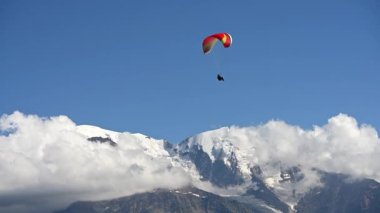 Paraglider Karlı Dağ Tepeleri 'nin üzerinde Yavaş Hareket Ederek Uçuşunun keyfini çıkarıyor.