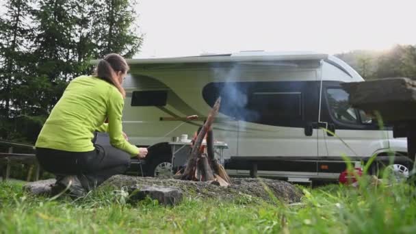 荒野のキャンプとキャンプファイヤーの時間 白人ロンリー女性はRvパークで一人で時間を過ごすいくつかの食品を調理 — ストック動画