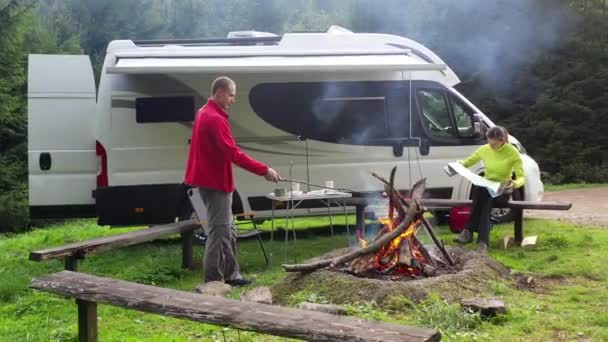 40代の白人夫婦が現代のキャンパー ヴァンで野外キャンプを楽しむ — ストック動画
