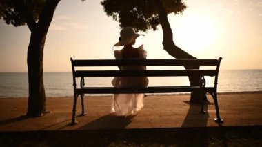 Uzun Beyaz Elbiseli Beyaz Kadın ve Deniz Kenarı Sırasında Güneş Şapkalı Zarif Emekli Beyaz Kadın