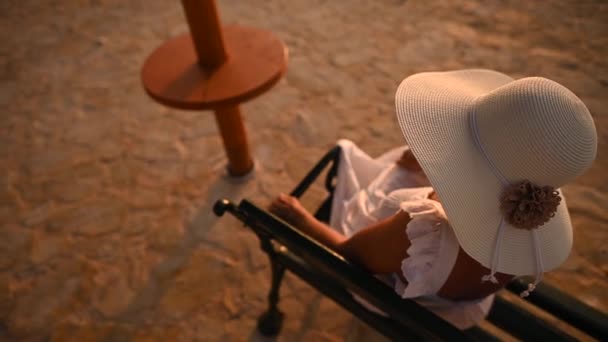 Beyaz Güneş Şapkalı Beyaz Kadın Marina Bench Oturuyor Sıcak Yaz — Stok video