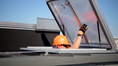 Kafkasyalı işçi, binanın tepesine çıkmak için cam çatıyı kaldırıyor.
