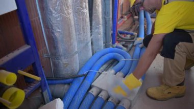 HVAC Isıtma ve Soğutma Teknisyeni Havalandırma Merkezini Yeni Yapılmış Ticari Binanın içinde Tamamlıyor