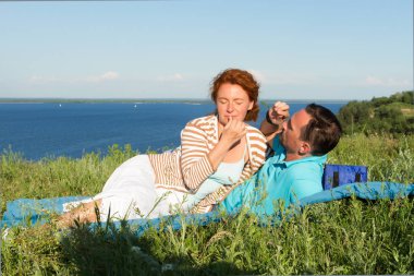 Çekici çift çimenlerde büyük göl, biraz dinlen. Sevgi dolu iki yaz günü içinde. mutlu çift yalancı. eğleniyor ve güzel doğanın keyfini aşık genç çift