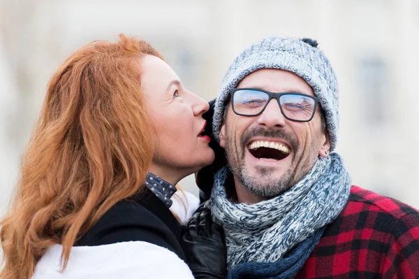 Smiled guy listen to woman. Happy men from woman story. Woman whispers to men in glasses. Close up of men opened mouth. Woman talks funny story to guy. Men in glasses likes whisper and happy.