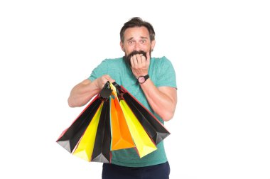 Beyaz arka planda alışveriş torbası olan sakallı yakışıklı bir adam. İndirim ve indirim kavramı. Satış sezonunda kağıt torbalarla alışveriş yapan adam. Şaşırmış suratlı hippi alışverişe düşkündür..