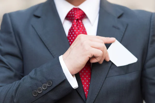 Fechar Mão Empresário Segurando Cartão Visita Sobre Bolso Terno Isolado — Fotografia de Stock