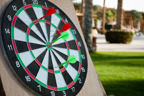 Darts ring with arrows. Green and red arrows in darts. Close up darts with arrows on green background