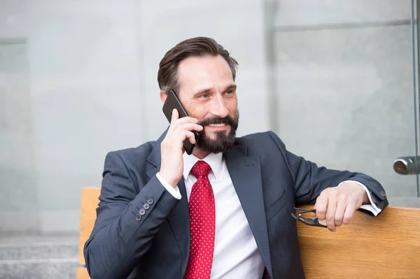 Retrato Homem Negócios Falando Smart Phone Enquanto Sentado Banco Livre — Fotografia de Stock